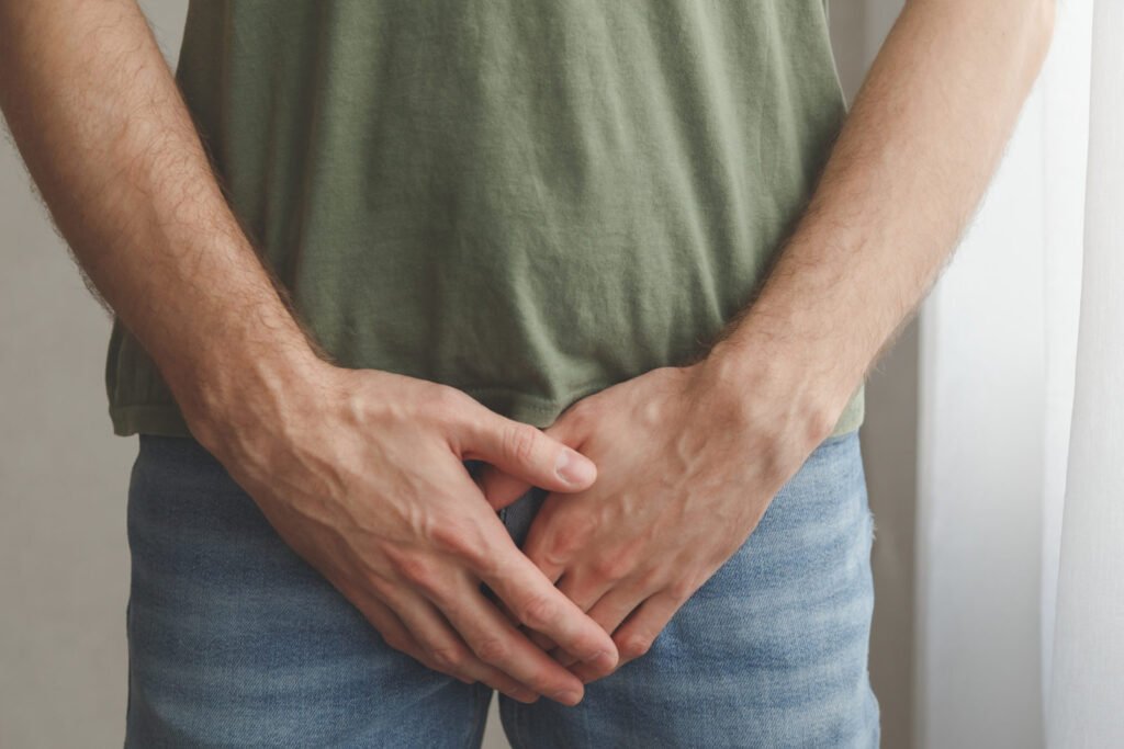 Homem em pé, mãos à frente do corpo